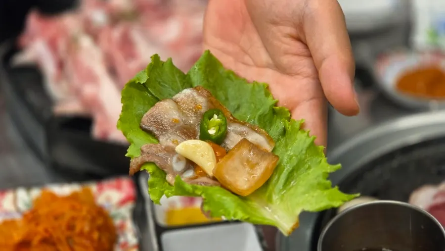 A bite of pork belly wrapped in lettuce
