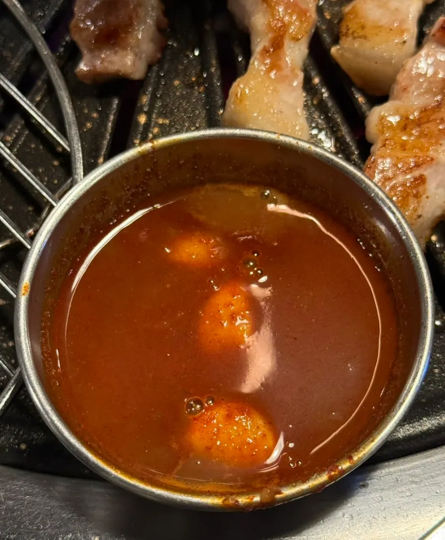 Ddotgalbi grilling over charcoal with myeoljeot on the side