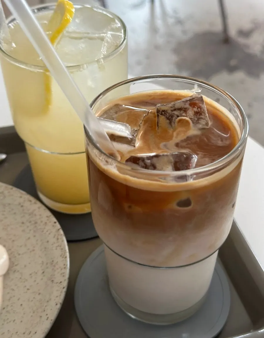 A decaf almond latte and a lemonade side by side