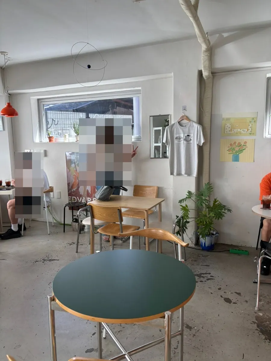 Café interior lit with sunlight through the floor-to-ceiling window