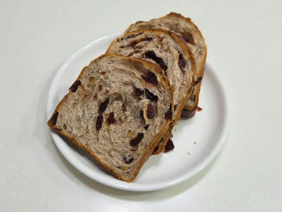 Cross-section of milk bread studded with walnuts and cranberries