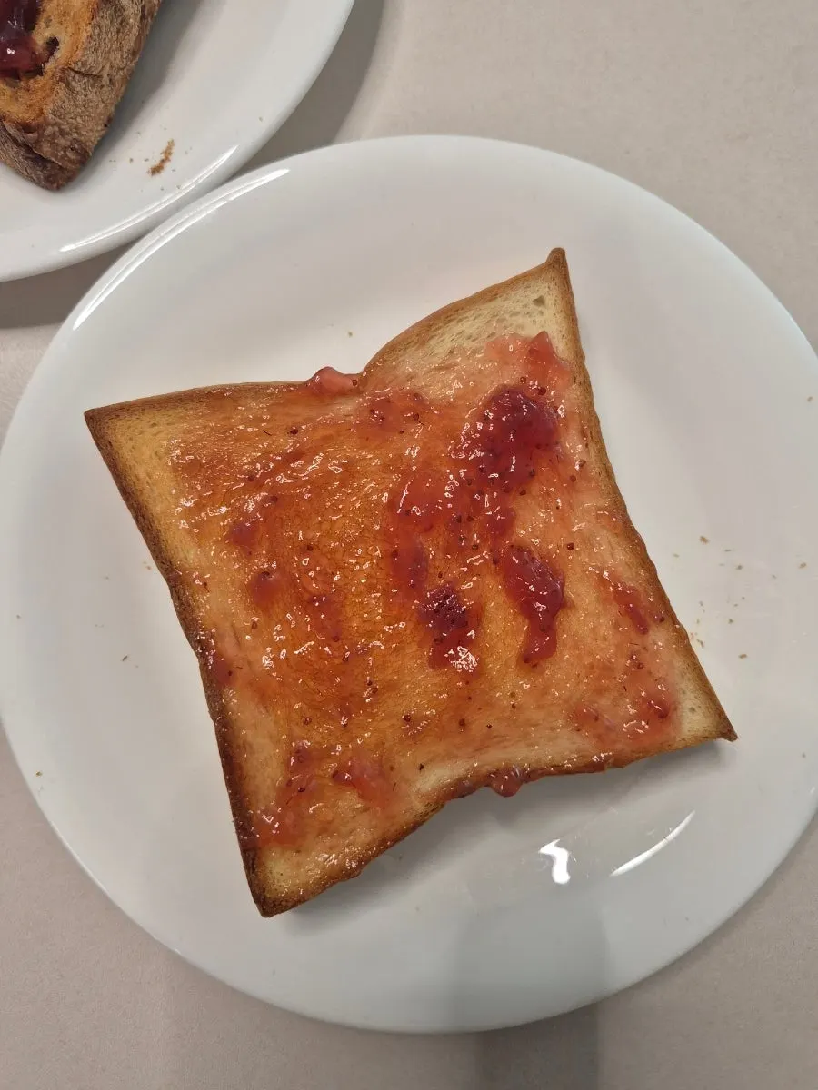 Jam-topped bread and coffee set on the table