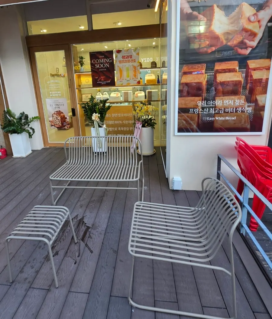 Storefront with terrace bench and potted plants
