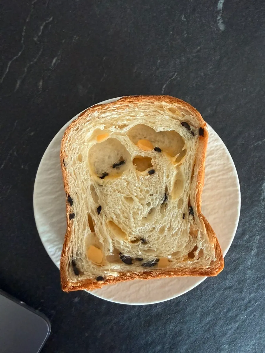 Cross-section of olive cheese milk bread studded with olives