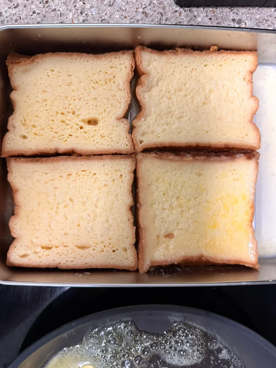 Thick-cut milk bread soaking in milk, egg, and sugar mixture