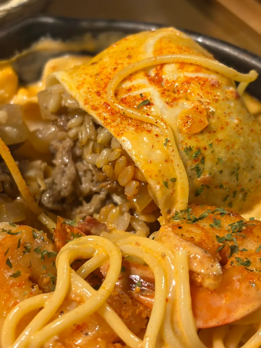 Chicken burrito placed on top of the pasta