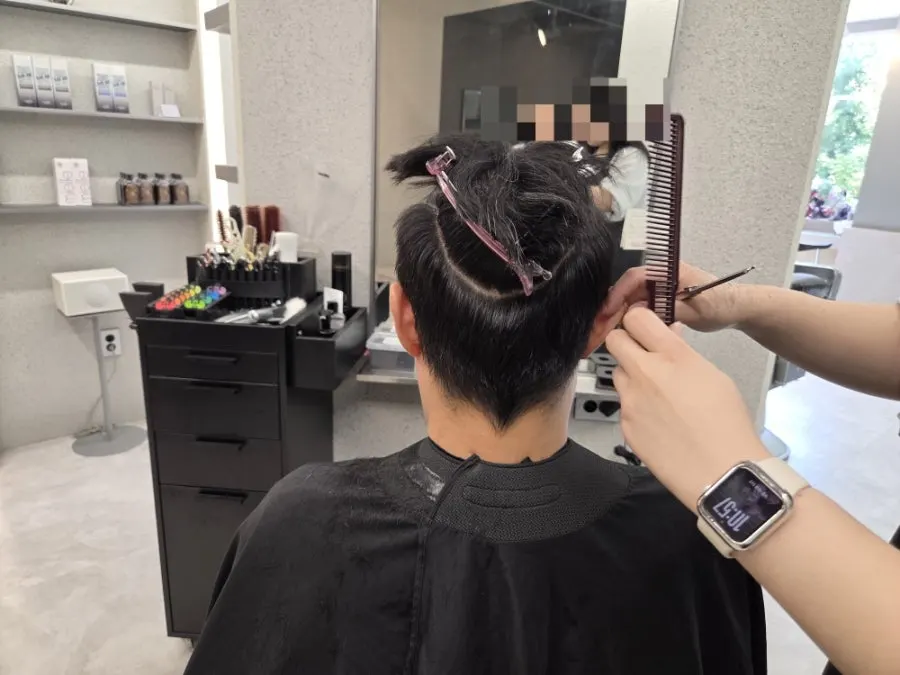 Men's haircut being done in carefully divided sections