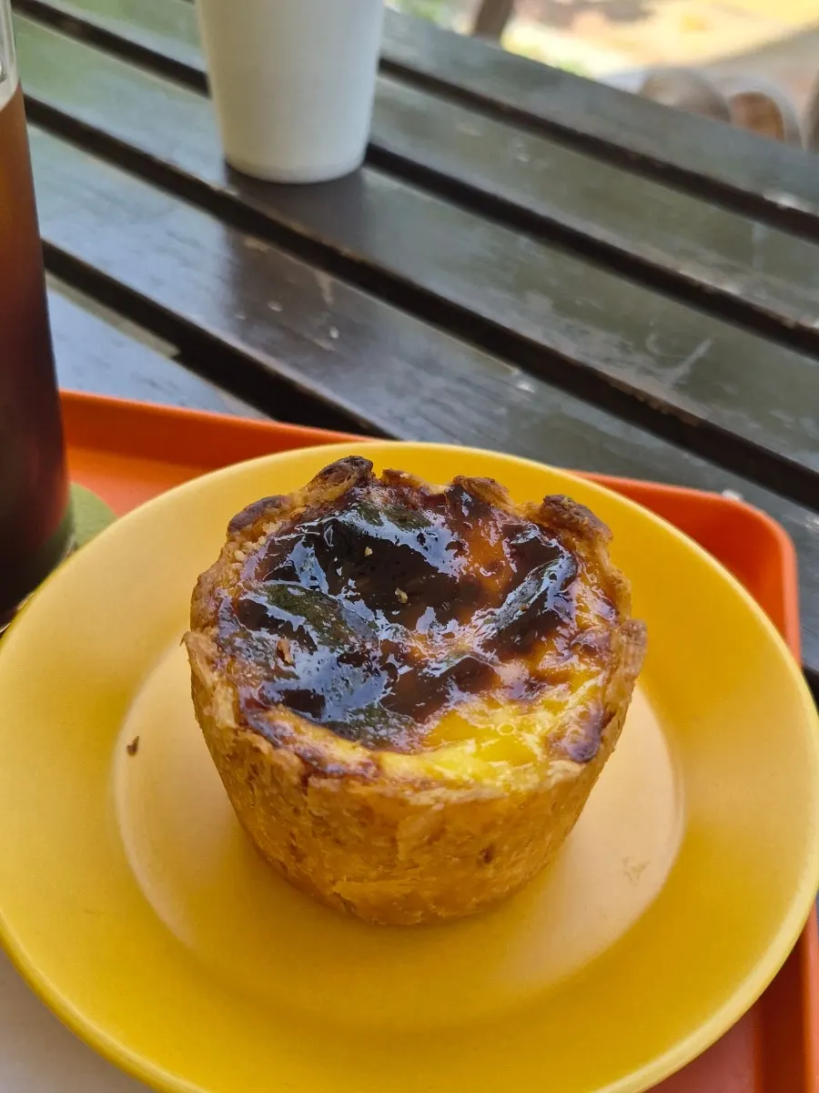 Egg tart and coffee together on a café table