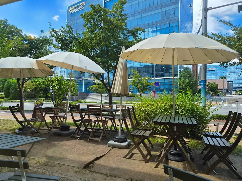 ที่นั่งพาราซอลบนระเบียงกลางแจ้งของ Eggroom ในวันอากาศแจ่มใส