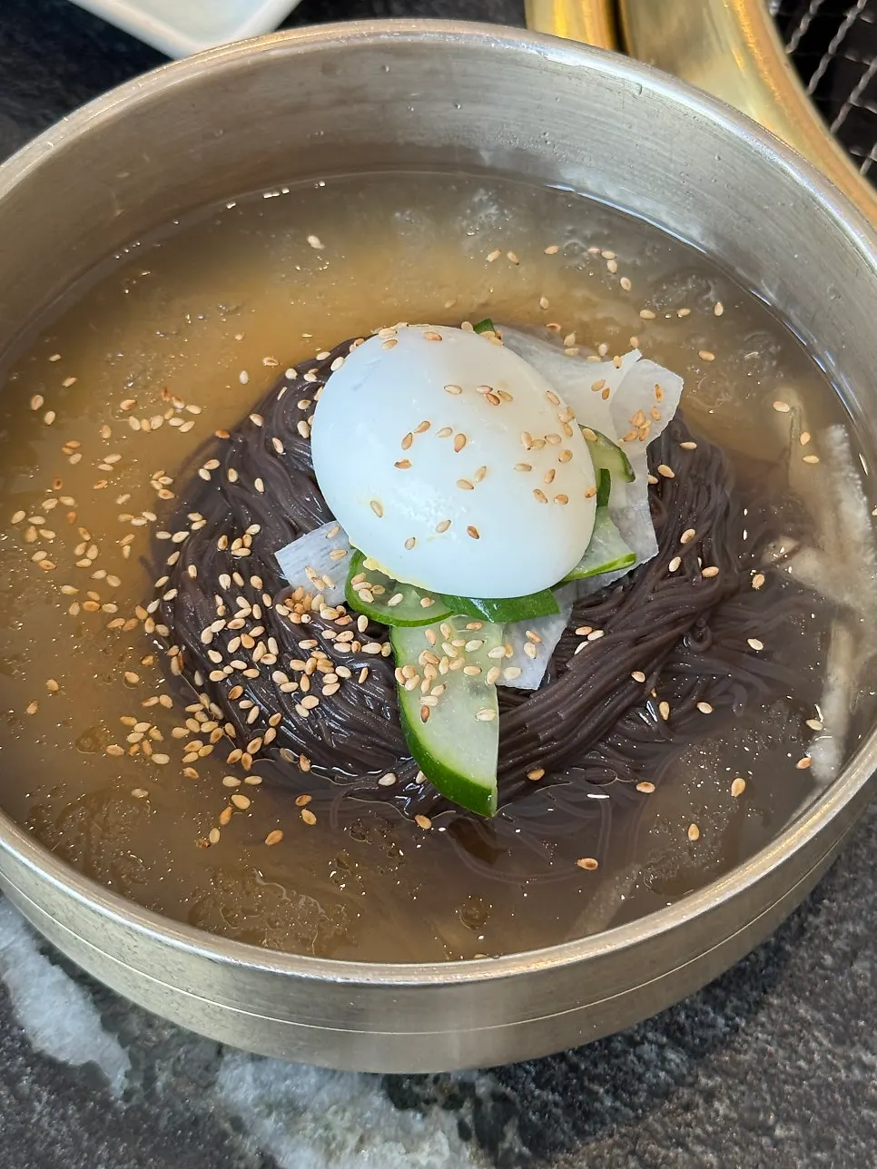 Table spread of naengmyeon and side dishes at Ihwajeong Galbi Myeongga