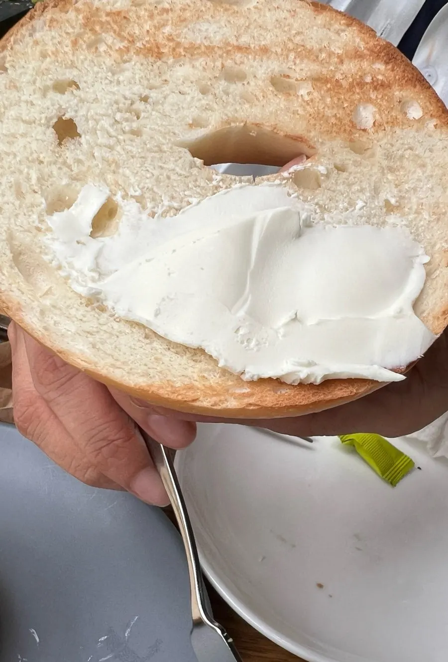 Cross-section of a bagel spread thick with cream cheese