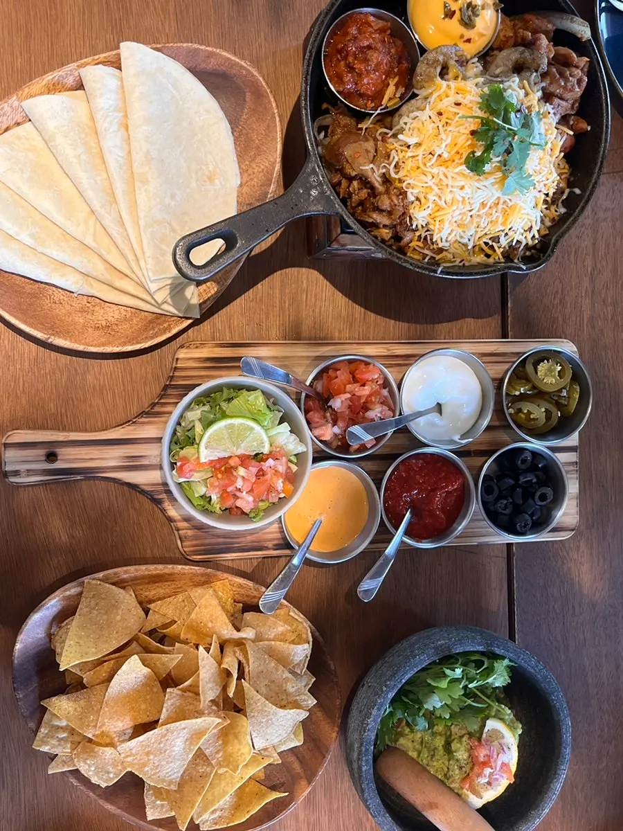 Side plate of salsa, sour cream, and other fajita toppings