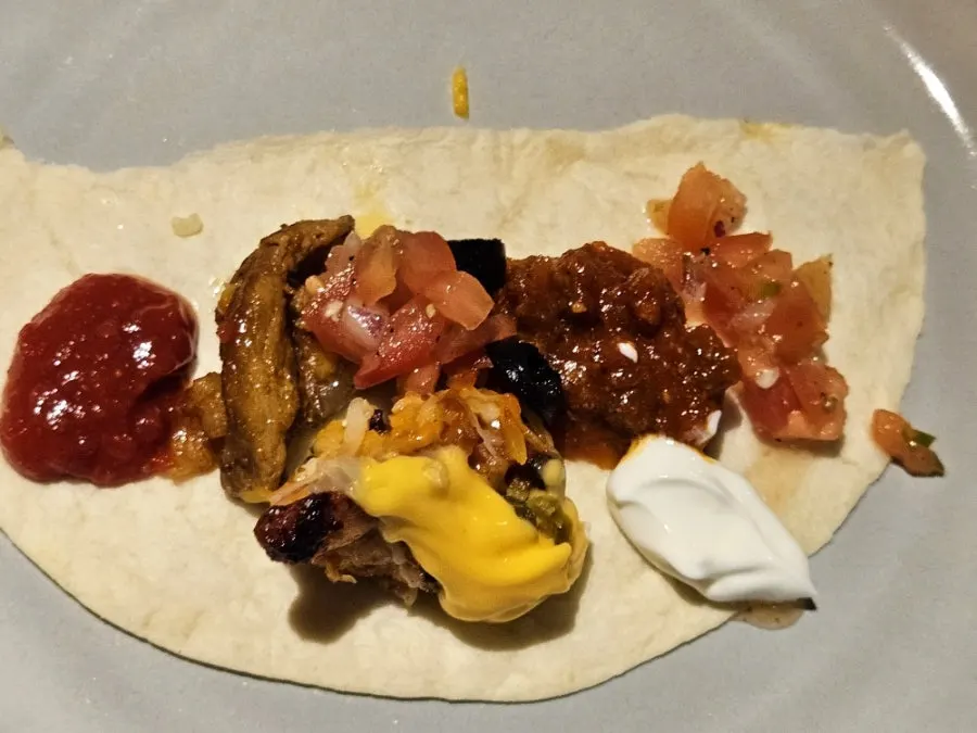 A tortilla topped with sour cream and jalapeños