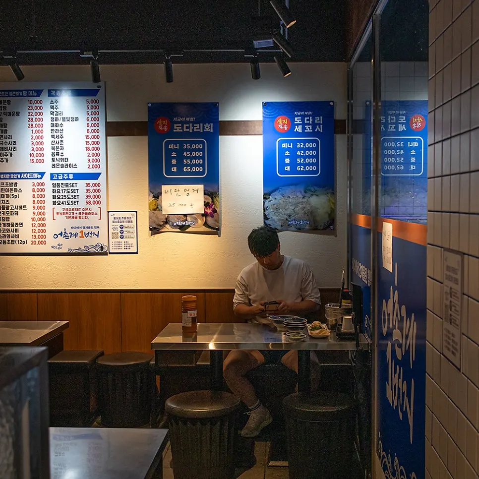 贴满菜品照片和海报的店内墙面