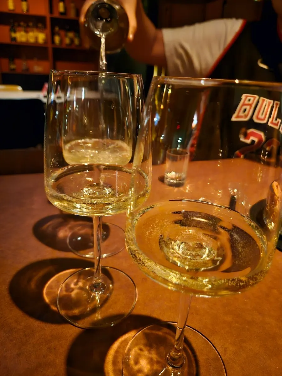 Botella de vino blanco abierta con copas