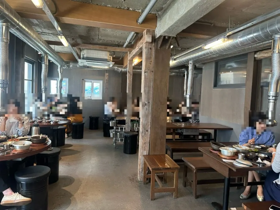 Interior with exposed ceiling and wood-toned tables