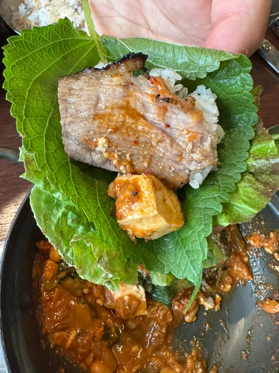 Lettuce and perilla wrap topped with bulgogi and gang-doenjang