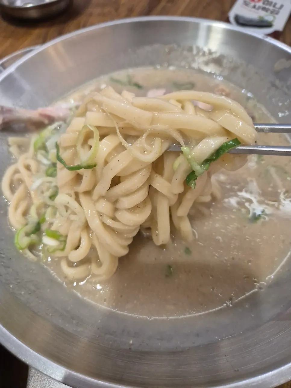 Lifting up the house-made noodles from the kalguksu