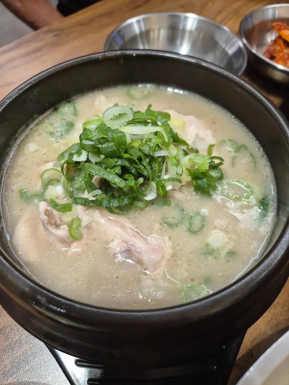 A bite of dak kalguksu topped with spicy silbi kimchi