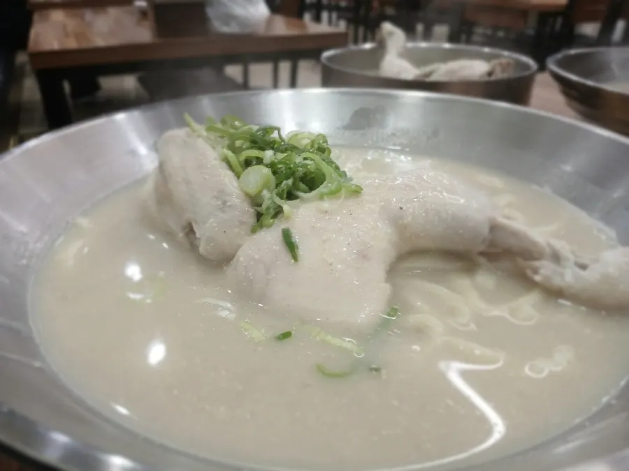 Half a whole chicken sitting on top of the kalguksu