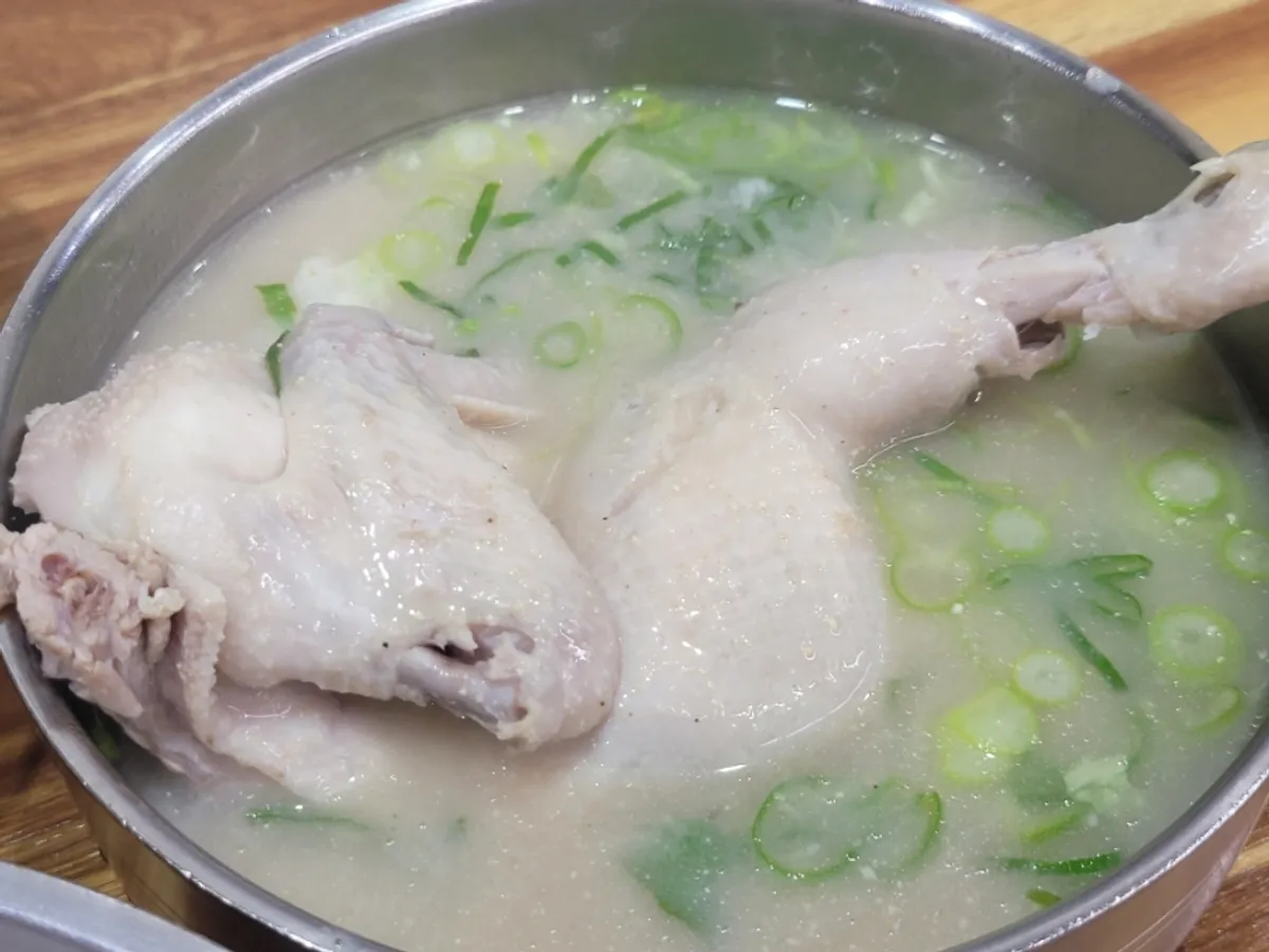 A spoonful of Eonyang-style kalguksu broth and noodles