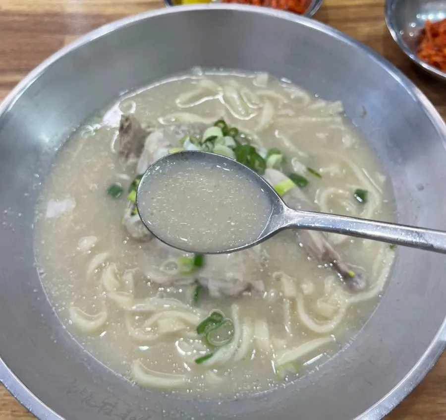 Kalguksu topped with a large whole piece of chicken