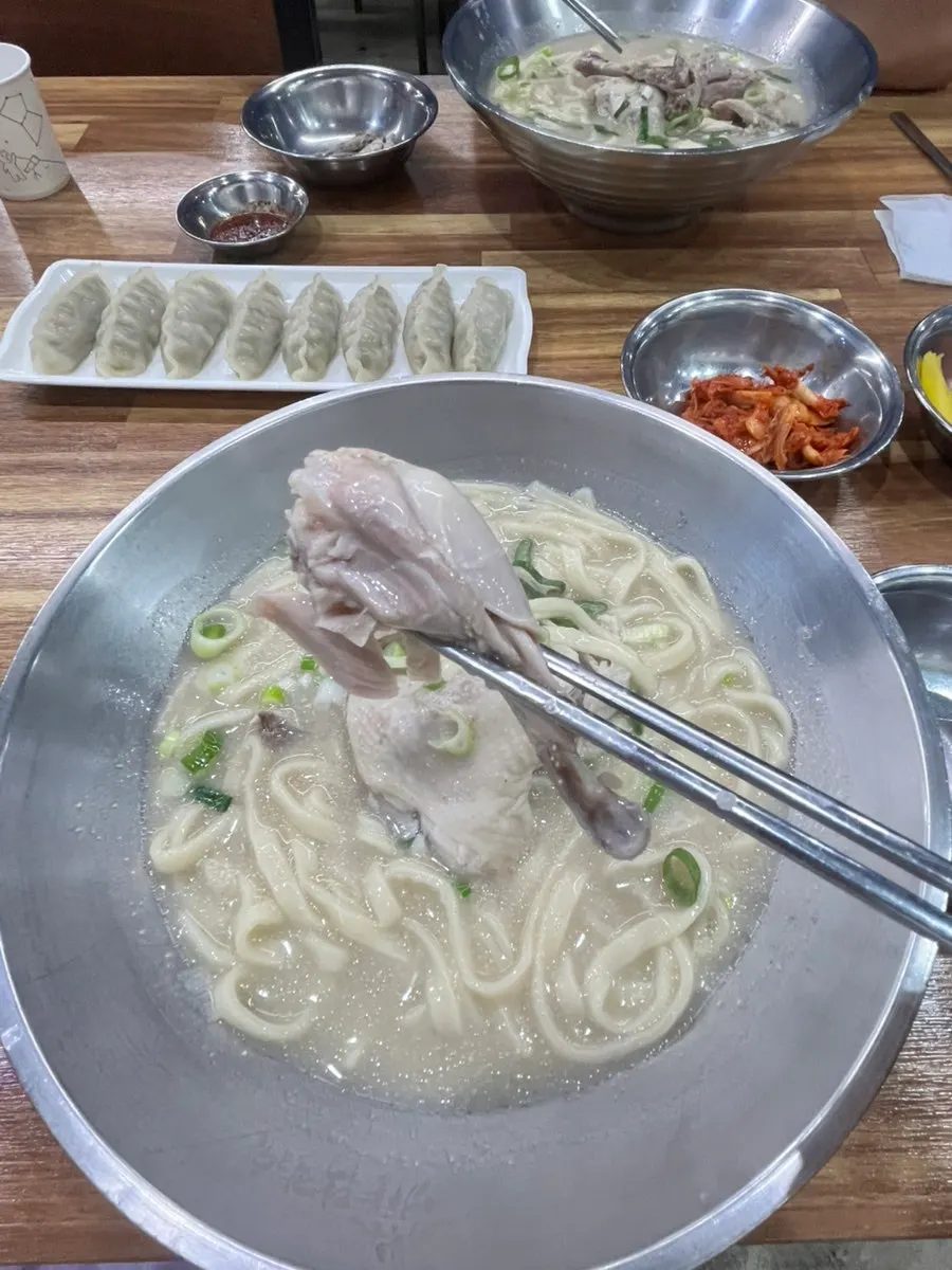 A spoonful of rich chicken-broth kalguksu