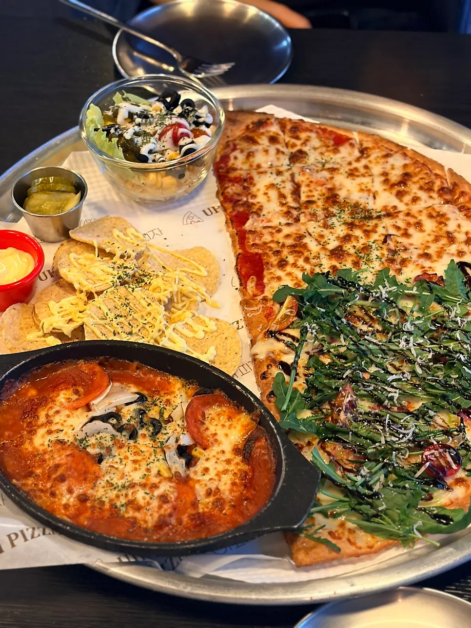 Mesa con pizza de rúcula y cerveza en Eopija, cerca de la estación Yeongchang