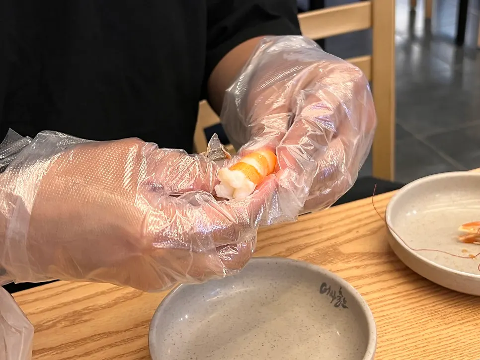 Peeling the shell off a grilled king prawn