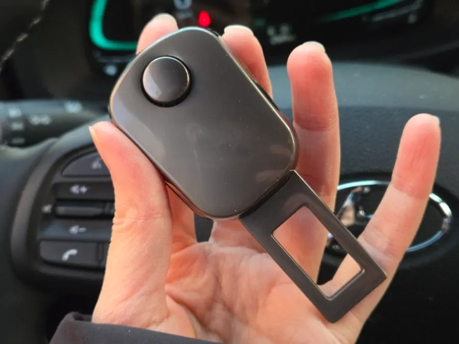 Glossy seat belt extender clip removed from the box