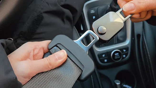 Removing a seat belt extender clip from a car buckle