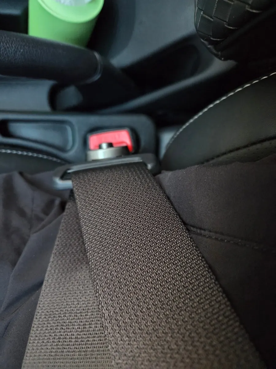 Comparison of a seat belt and extender clip worn over a long puffer coat