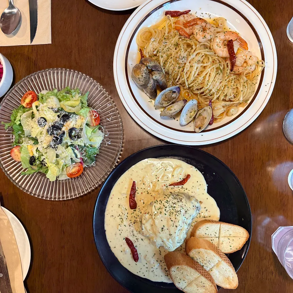 Full table spread with cream tenderloin steak, pasta, and salad