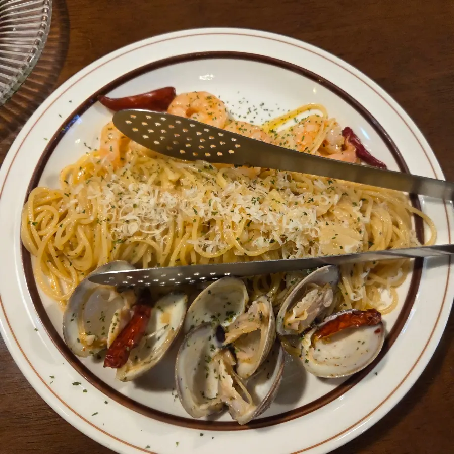 Shrimp aglio olio served with tongs