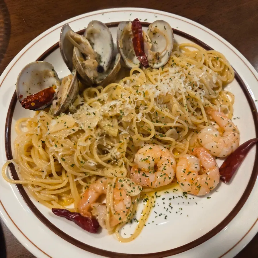 Aglio olio topped with clams and shrimp