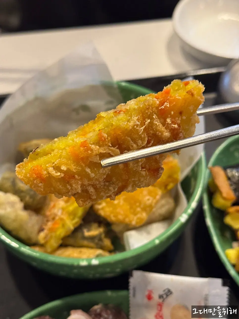 젓가락으로 집어 올린 밀떡 떡볶이