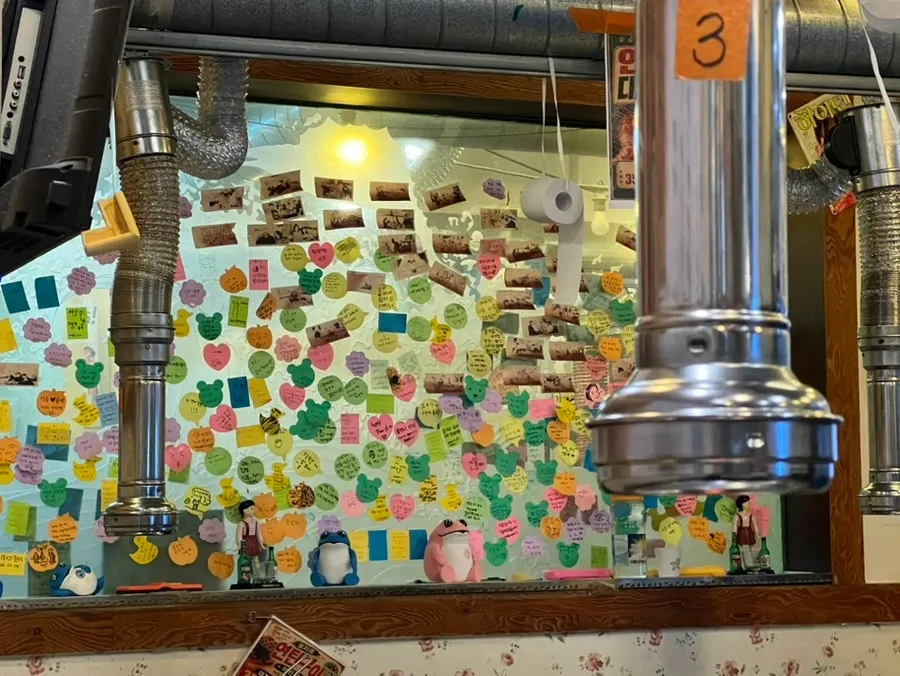 Customers' sticky-note guestbook messages on the window