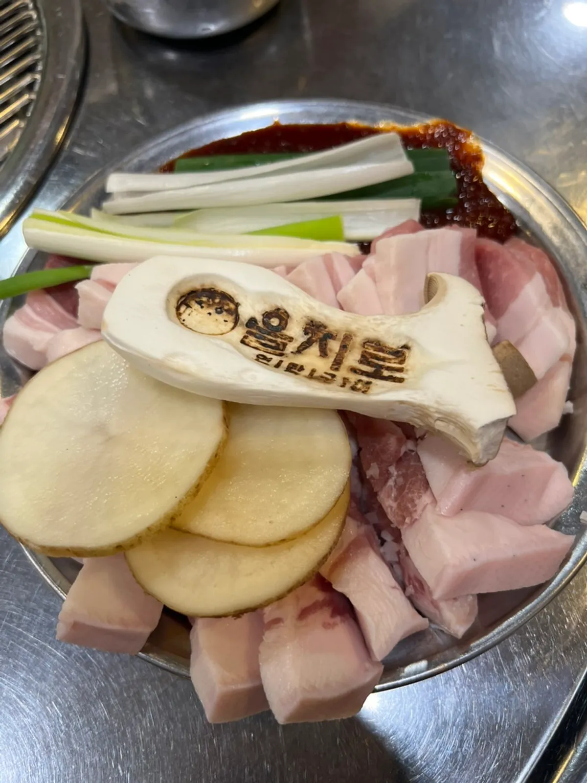 Meat on the charcoal grill alongside side dishes