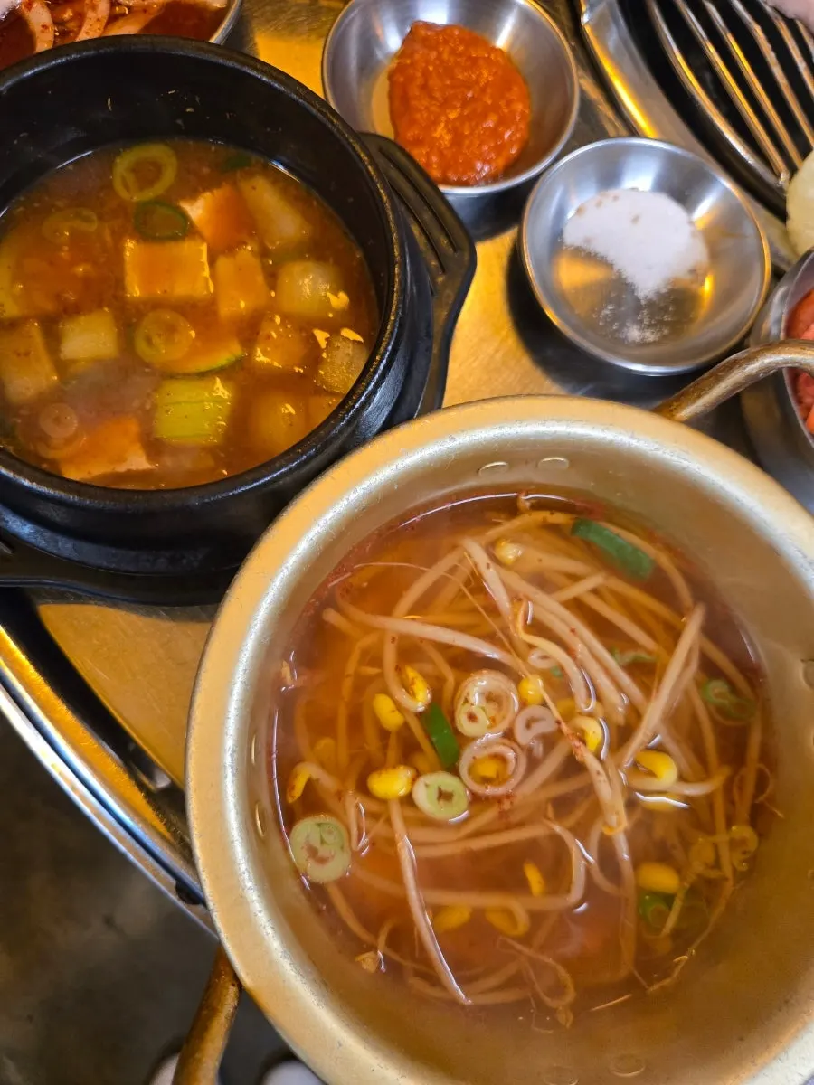 Table setting with doenjang jjigae and soybean sprout soup