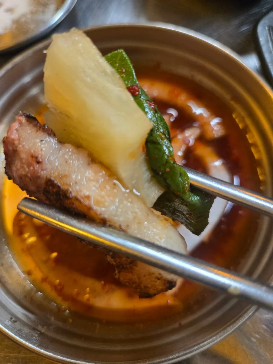 A piece of charcoal-grilled pork dipped in salt