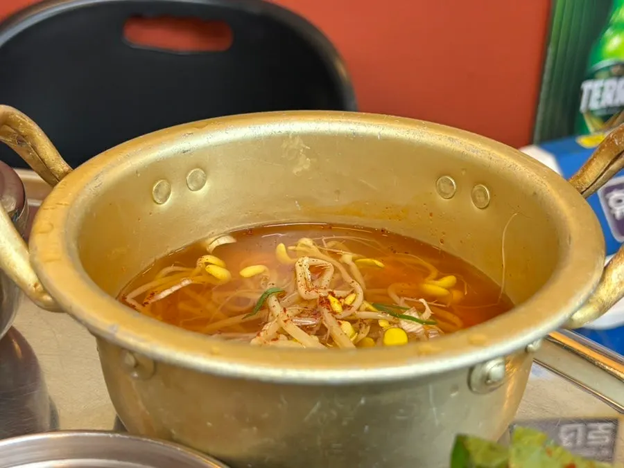 불판에 올려진 콩나물과 김치, 마늘