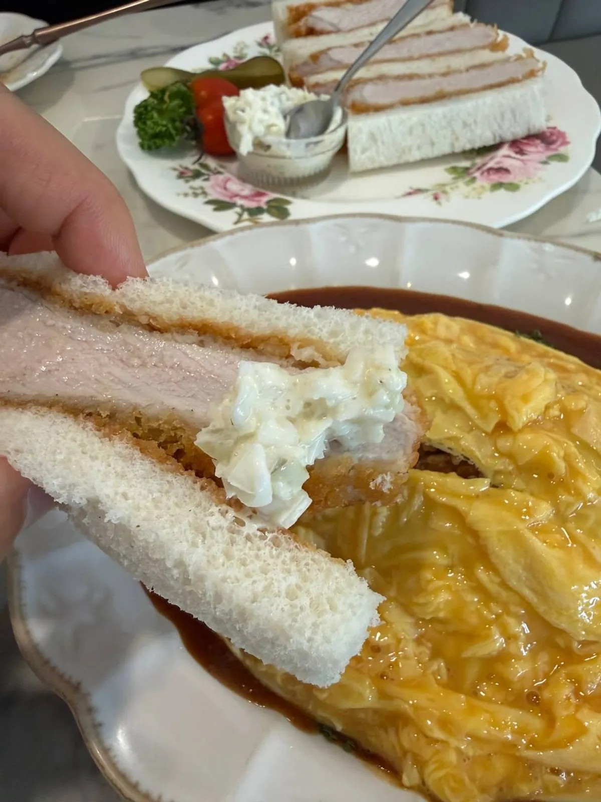 타르타르 소스를 올려 집어 든 카츠산도 한 조각