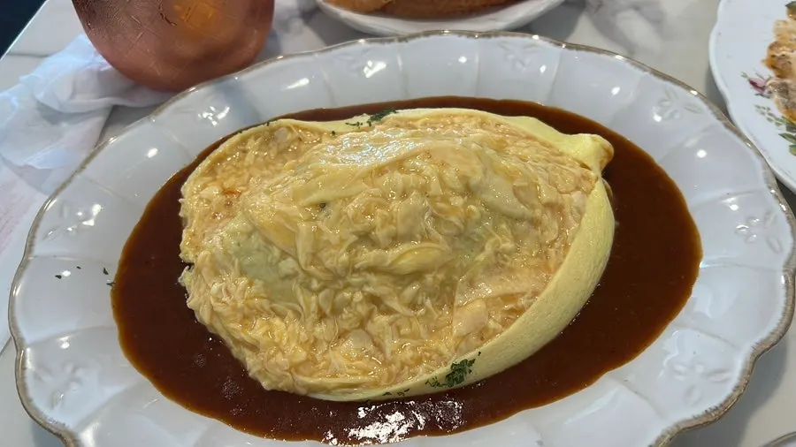 Table spread with pasta, omurice, and bread
