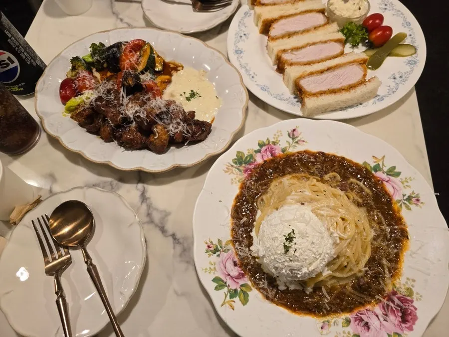 테이블에 차려진 파스타와 스테이크, 가츠산도 한 상