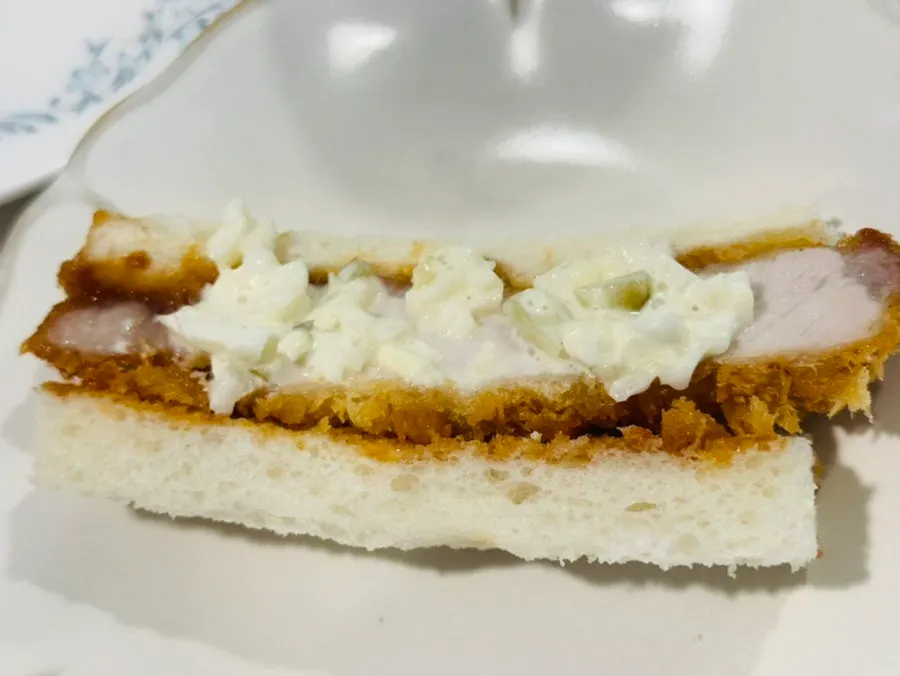 A piece of katsu sando topped with sauce