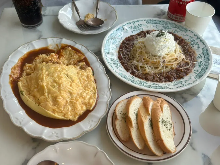 Full table spread of omurice and rose pasta