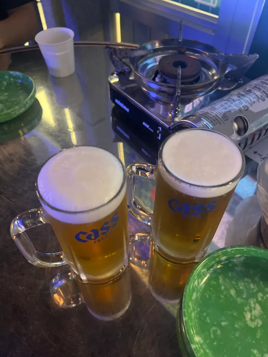 Glass of Cass draft beer with foam on top