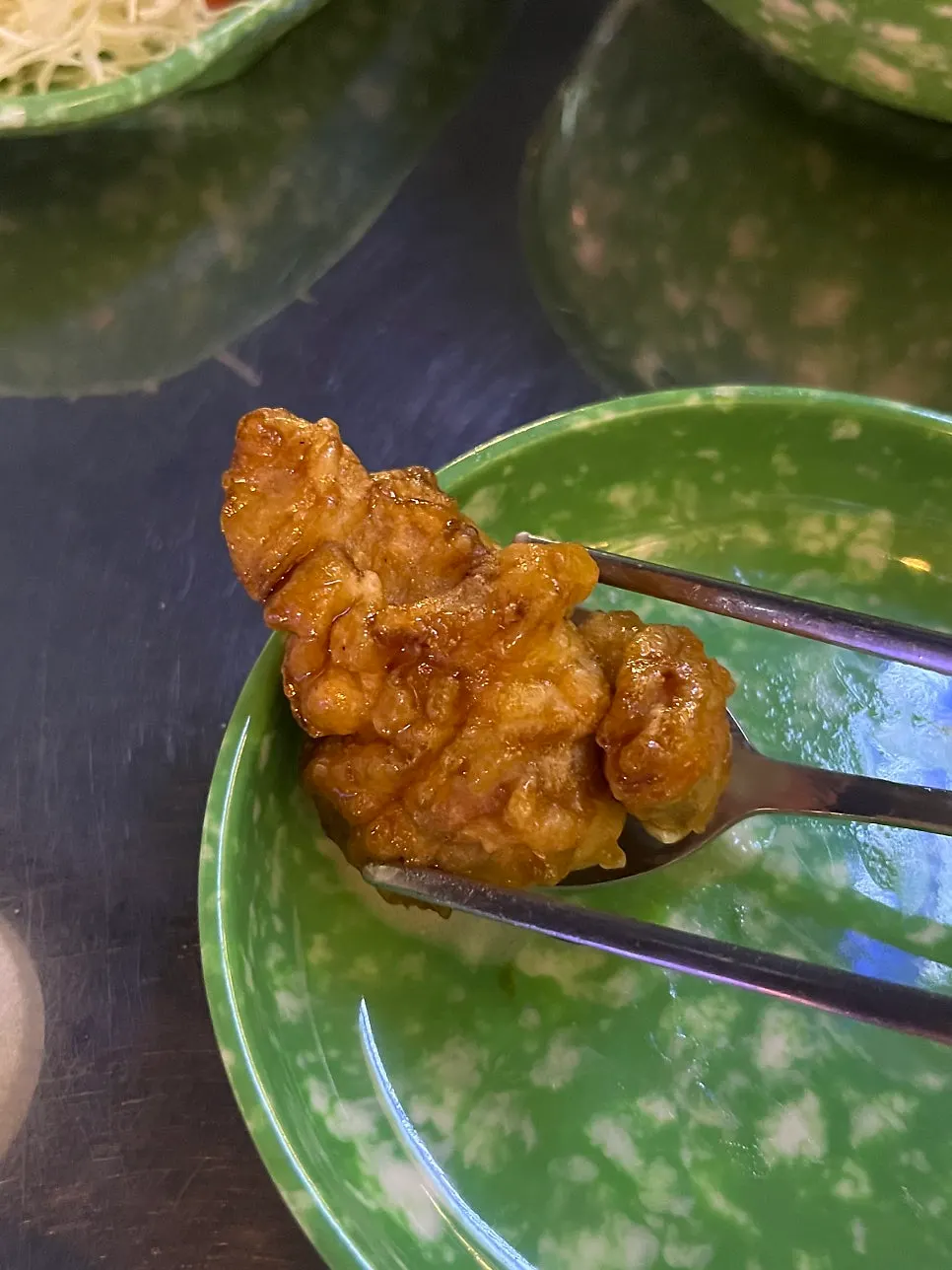 Medio plato de pollo en salsa de soja servido con ensalada de repollo