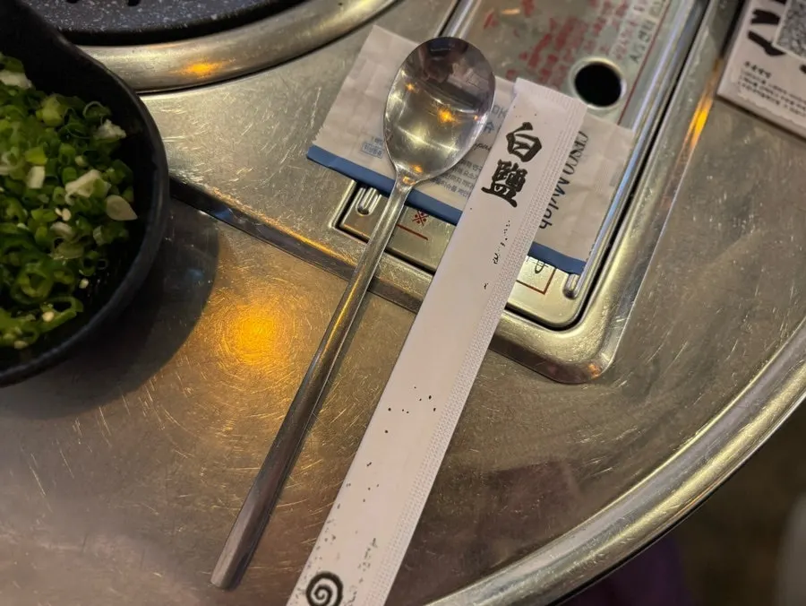 Place setting with spoon and wooden chopsticks