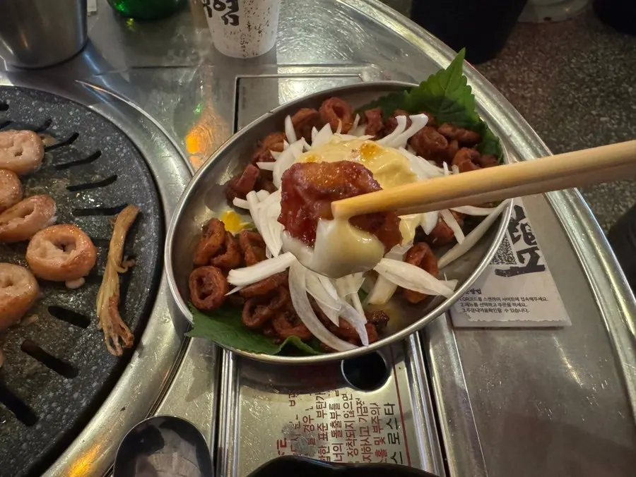 Seasoned makchang with sliced onion and garlic sauce